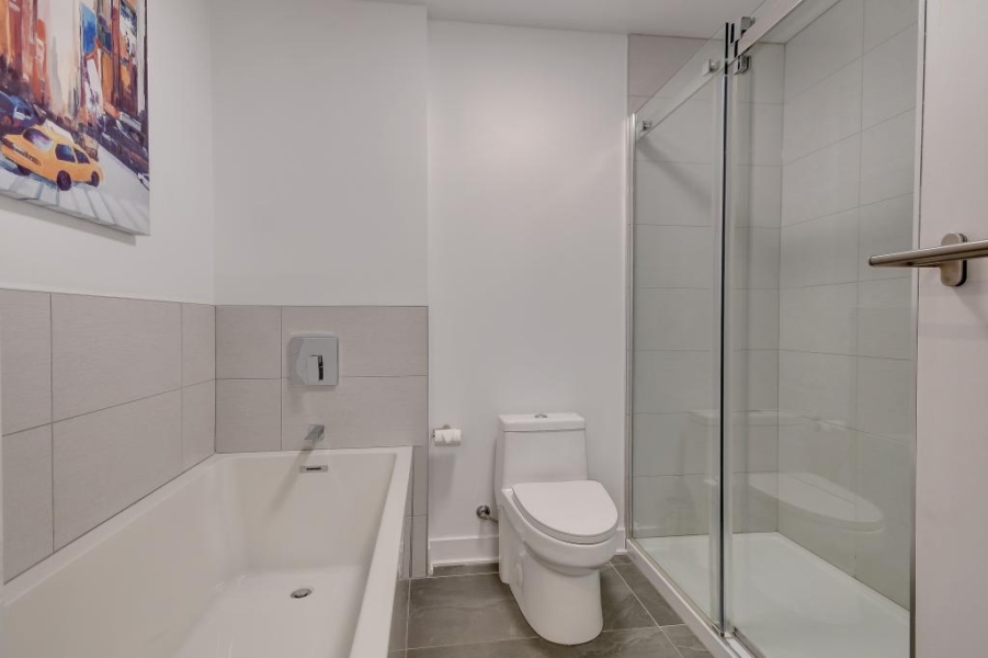 Salle de bain avec bain et douche vitrée séparés